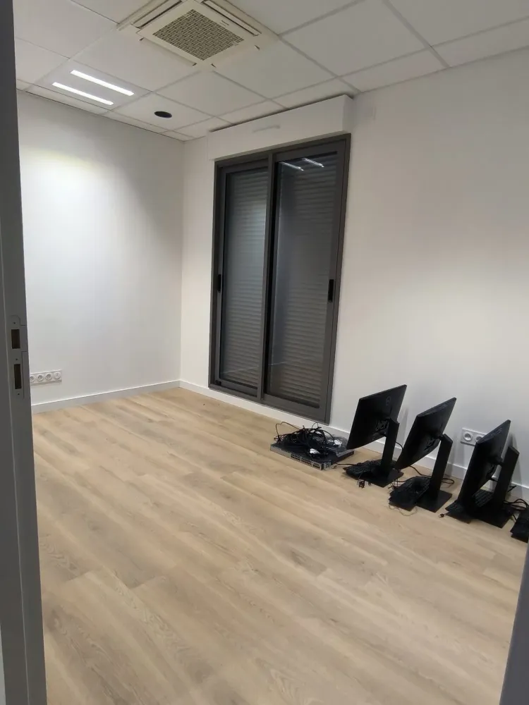 Pièce de bureau rénovée avec trois écrans au sol